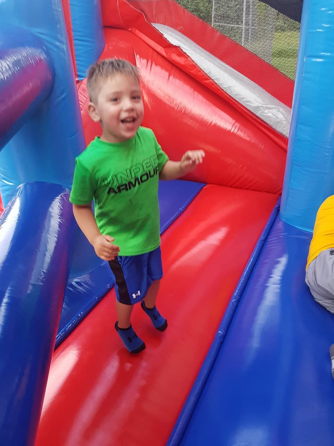 A laughing boy bouncing inside a castle