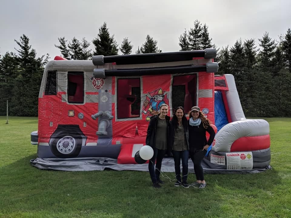 Guests in front of the Fire Truck Combo bouncy castle in a field