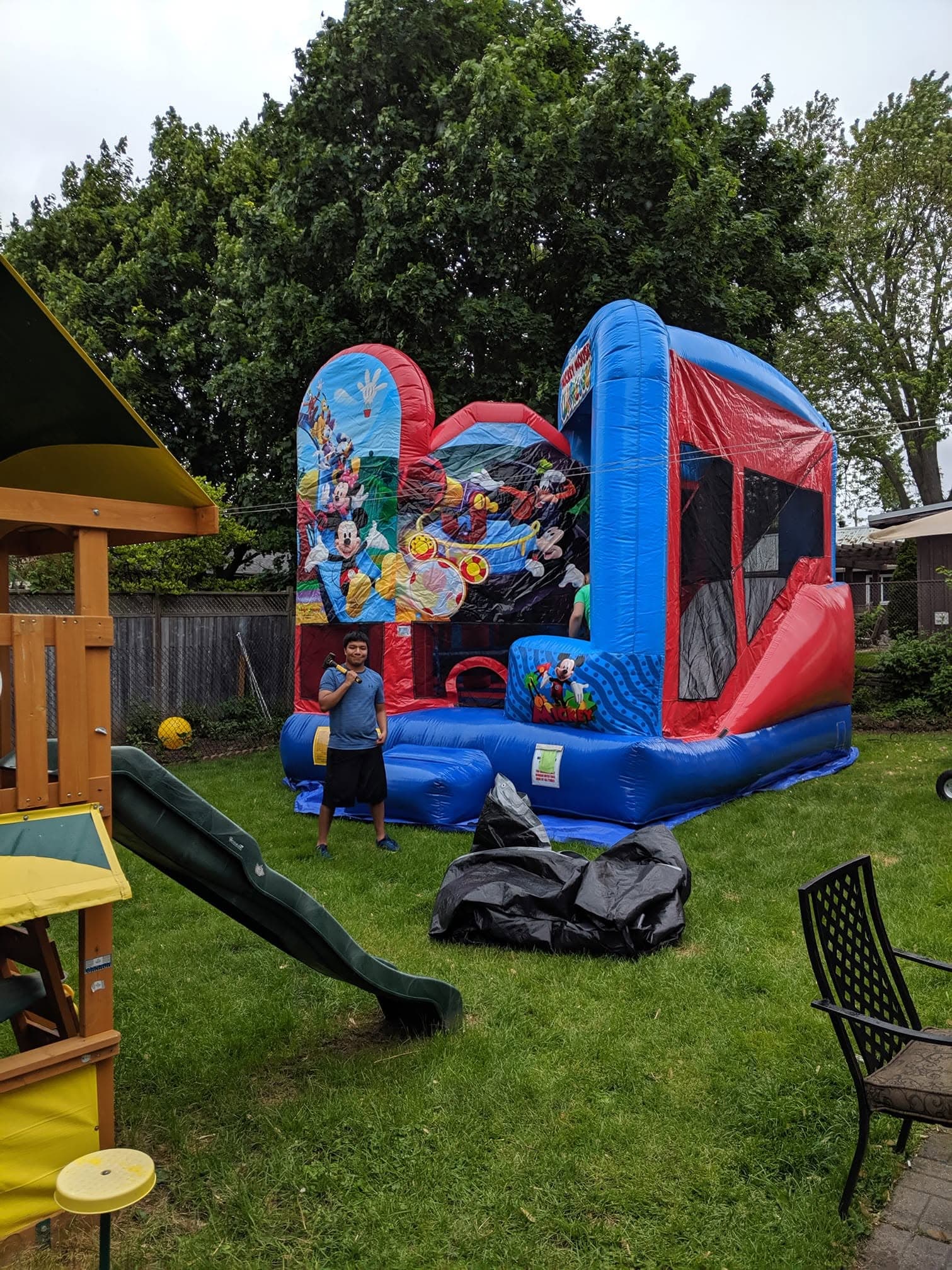 Mickey Mouse Clubhouse bouncy castle set up in a backyard